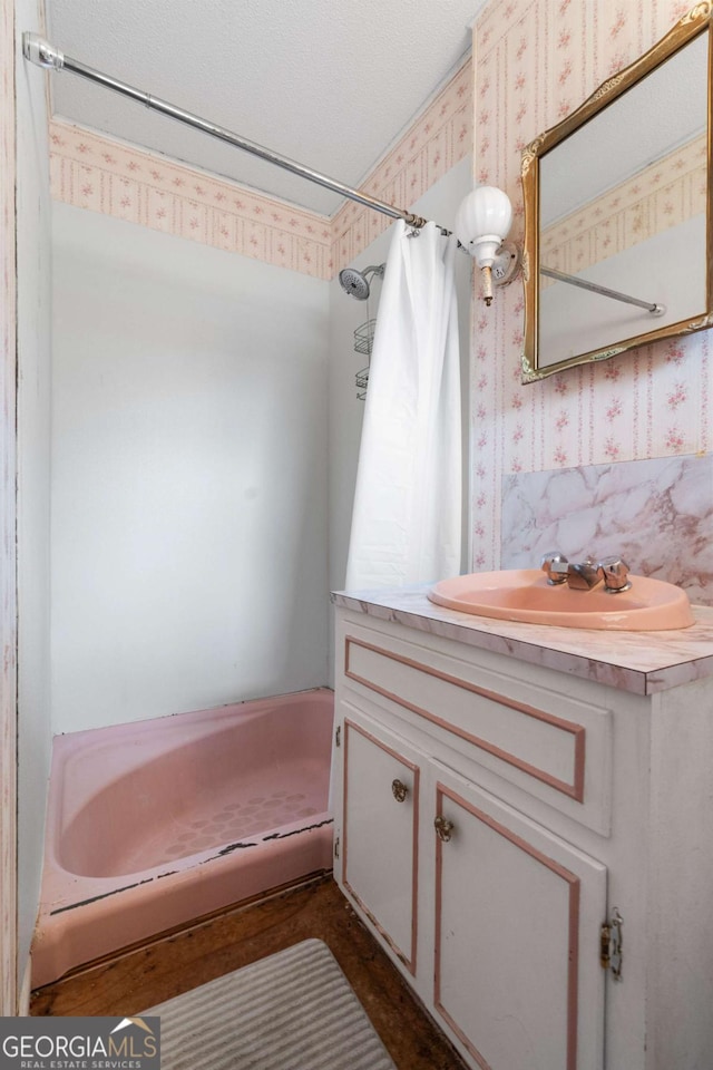 bathroom with sink, a textured ceiling, and a shower with shower curtain