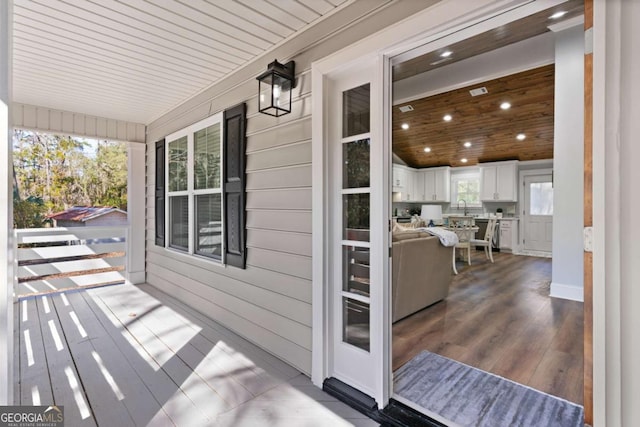 view of exterior entry featuring a porch and a sink