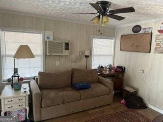 living room featuring plenty of natural light, ornamental molding, a wall mounted AC, and a textured ceiling