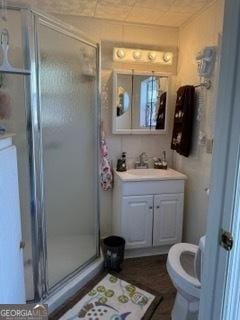 bathroom featuring vanity, toilet, and a shower with shower door