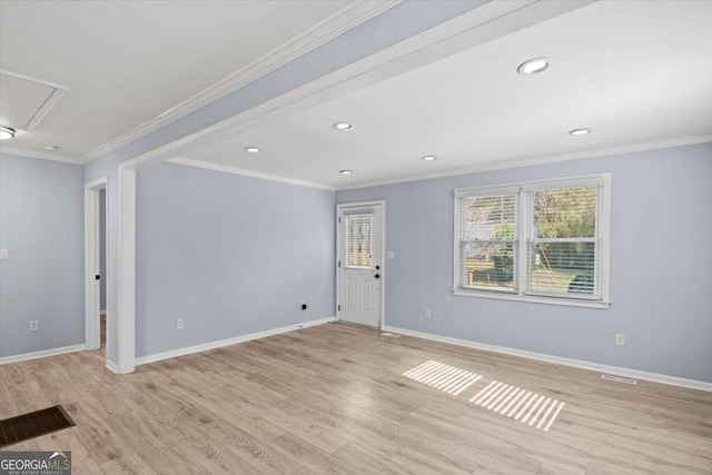 spare room featuring crown molding and light hardwood / wood-style floors