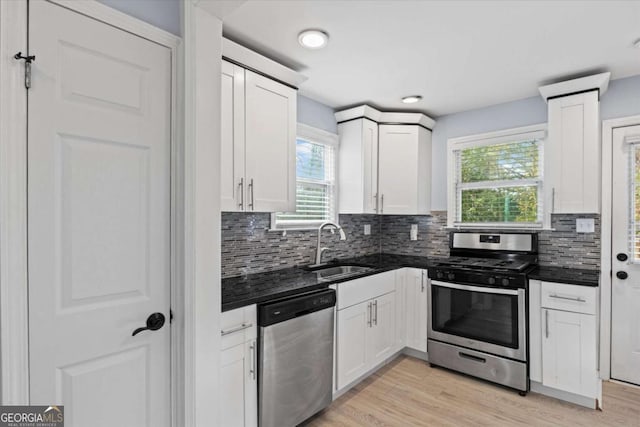 kitchen with sink, light hardwood / wood-style flooring, white cabinets, and appliances with stainless steel finishes