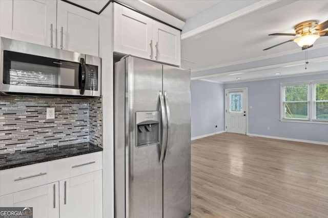 kitchen featuring tasteful backsplash, light hardwood / wood-style flooring, dark stone counters, stainless steel appliances, and white cabinets