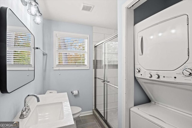 laundry room with stacked washing maching and dryer and sink