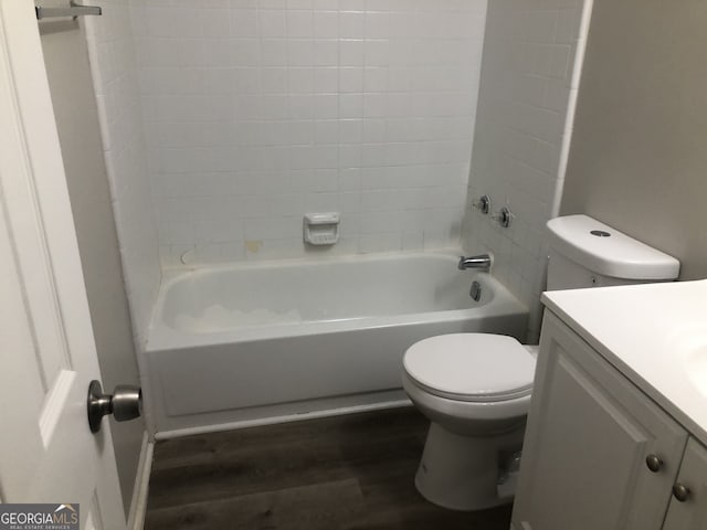 full bathroom with tiled shower / bath, wood-type flooring, toilet, and vanity