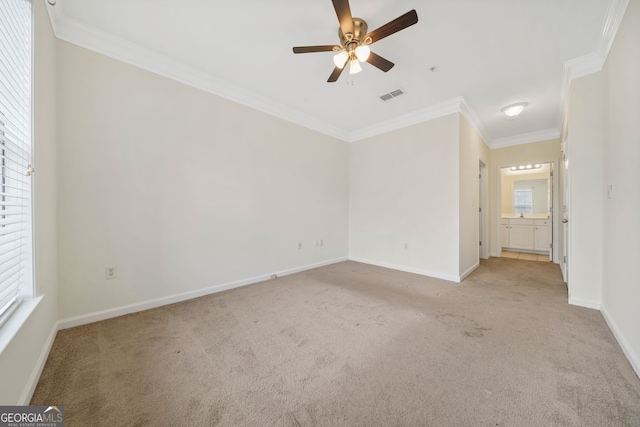 spare room featuring crown molding, light colored carpet, and ceiling fan