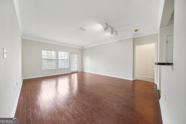 empty room featuring dark wood-type flooring, ornamental molding, and rail lighting