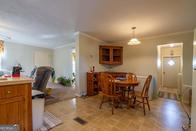 dining space featuring ornamental molding and a textured ceiling