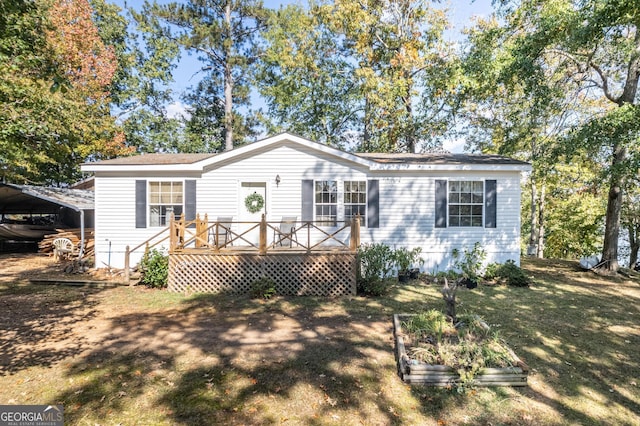 view of front of home with a wooden deck, a front lawn, and a carport