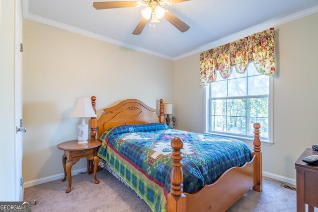 carpeted bedroom with ceiling fan and ornamental molding