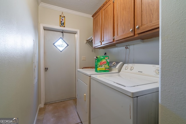 laundry room featuring crown molding, washer and clothes dryer, cabinets, and a textured ceiling