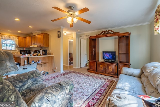 living room with ornamental molding and ceiling fan