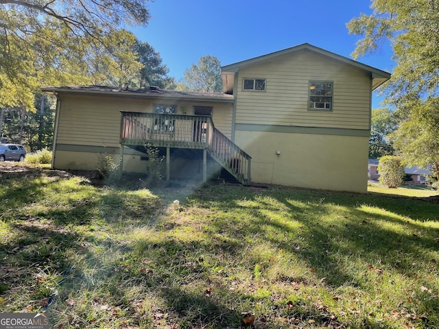 back of house with a wooden deck and a yard