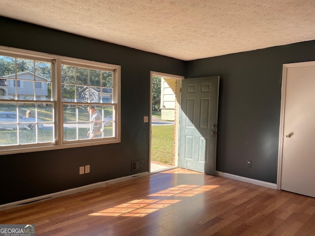 interior space with a textured ceiling and light hardwood / wood-style flooring