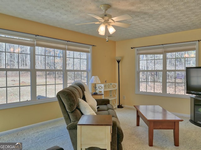 living room featuring ceiling fan, carpet floors, and a textured ceiling