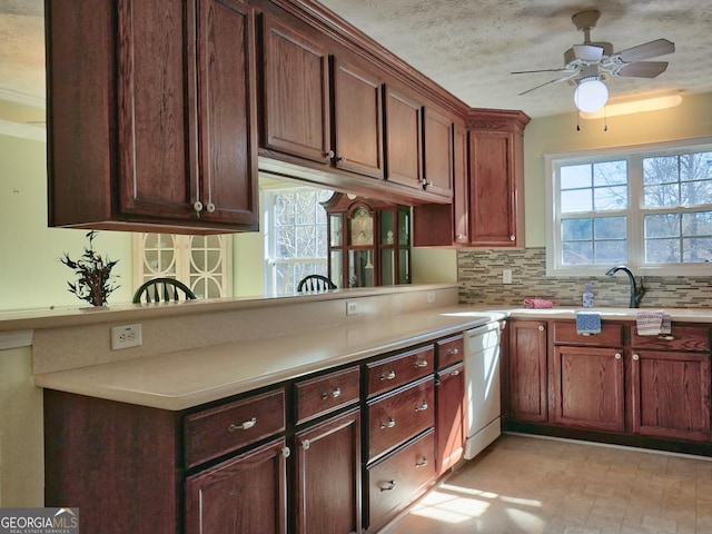 kitchen with dishwasher, sink, decorative backsplash, ceiling fan, and kitchen peninsula