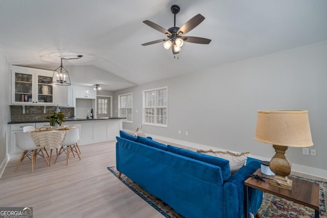 living room featuring ceiling fan, lofted ceiling, sink, and light hardwood / wood-style floors