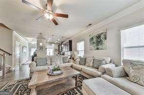 living room with crown molding and ceiling fan