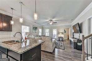 kitchen with plenty of natural light, a center island, sink, and dark brown cabinets