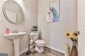 bathroom featuring sink, hardwood / wood-style flooring, and toilet