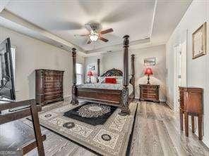 bedroom with a tray ceiling and hardwood / wood-style flooring