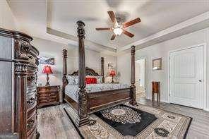 bedroom featuring crown molding, wood-type flooring, and a raised ceiling