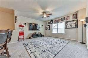 unfurnished living room with ceiling fan and carpet