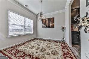 dining area with ornamental molding and a chandelier