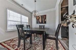 dining space with an inviting chandelier and ornamental molding