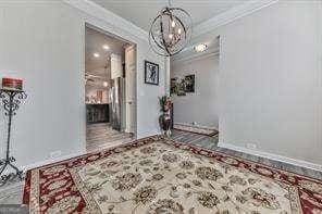 corridor with a notable chandelier and crown molding