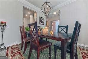 dining room with ornamental molding and a chandelier