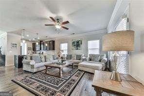 living room with crown molding, hardwood / wood-style floors, and ceiling fan