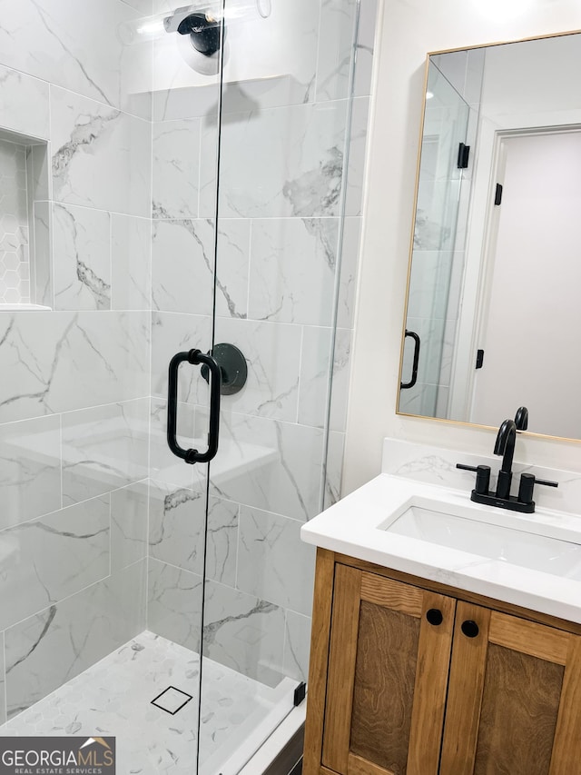 bathroom with vanity and a shower with shower door