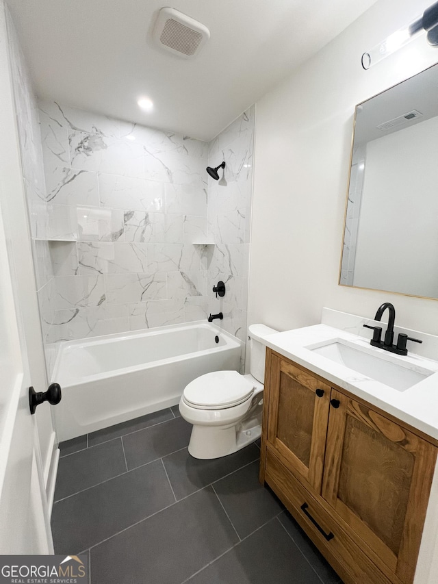 full bathroom featuring tiled shower / bath combo, vanity, tile patterned floors, and toilet