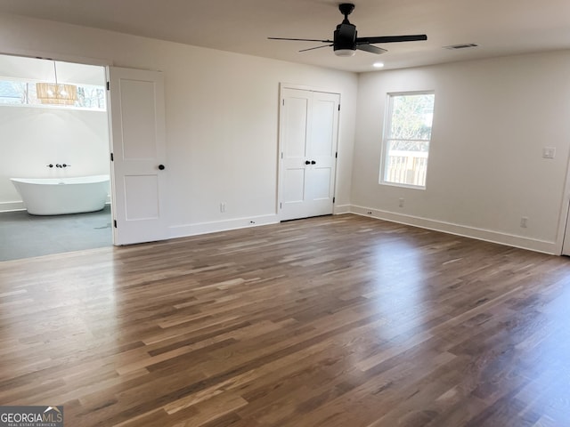 unfurnished bedroom with dark hardwood / wood-style flooring and ceiling fan