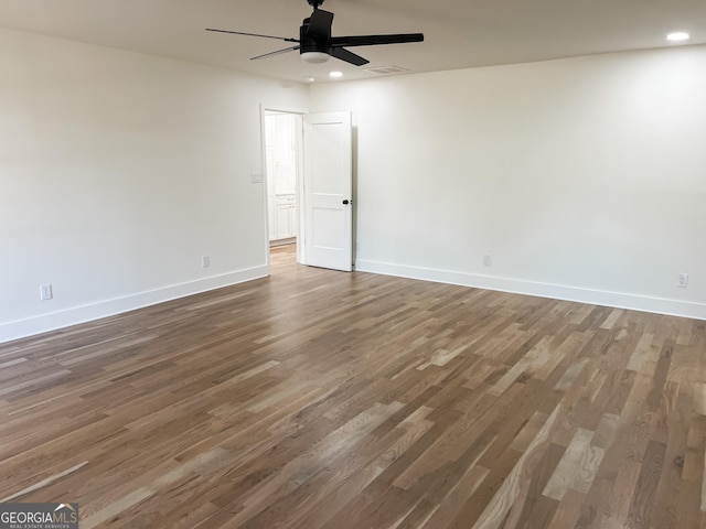 empty room with ceiling fan and dark hardwood / wood-style floors