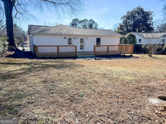 rear view of house featuring a yard and a deck