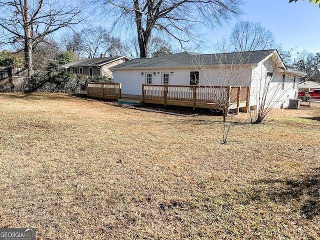 rear view of property with a wooden deck, central AC, and a lawn