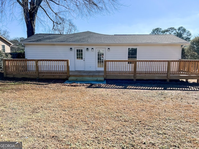 view of front facade featuring a wooden deck and a front lawn