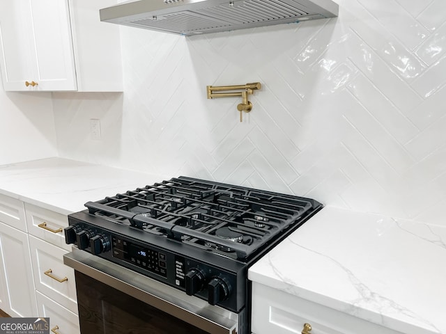 kitchen with tasteful backsplash, white cabinetry, light stone counters, custom range hood, and black range with gas cooktop