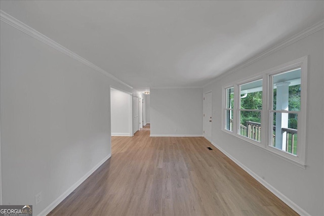 spare room featuring crown molding and light hardwood / wood-style floors