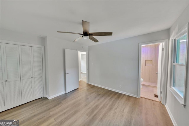 unfurnished bedroom featuring light hardwood / wood-style flooring, a closet, ceiling fan, and ensuite bathroom