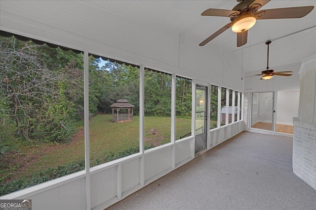 unfurnished sunroom featuring ceiling fan