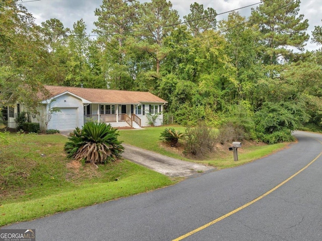 view of front of property featuring a garage, a front yard, and a porch