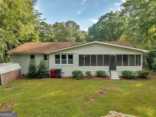 back of property featuring a lawn and a sunroom