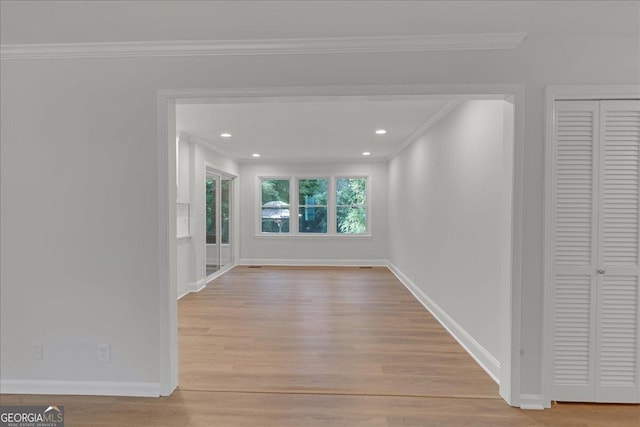 hallway with crown molding and light hardwood / wood-style flooring