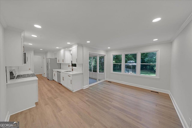 kitchen with white cabinetry, ornamental molding, stainless steel appliances, and sink