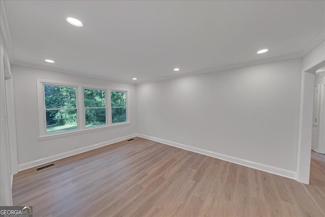 empty room featuring crown molding and light hardwood / wood-style flooring