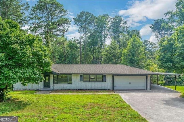 view of front facade with concrete driveway, an attached garage, a front yard, a carport, and brick siding