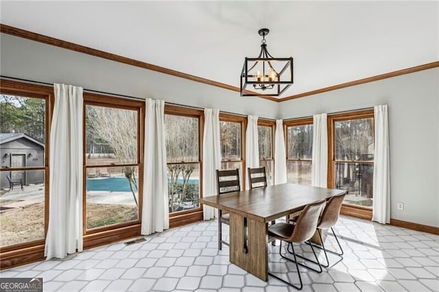 dining room featuring ornamental molding, plenty of natural light, and a notable chandelier